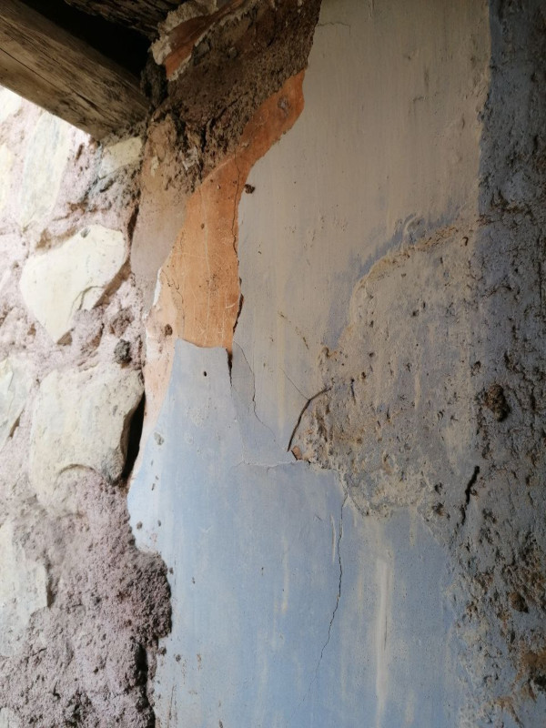 Restos de yeso pintado en la balconada del arquillo. Se observan diversas capas, algunas azules y otras rojizas