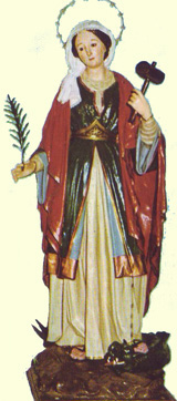 Santa Marina representada con palma en mano derecha, mientras que con la izquierda sostiene un mazo y el extremo de una cadena con la que tiene preso a un dragón