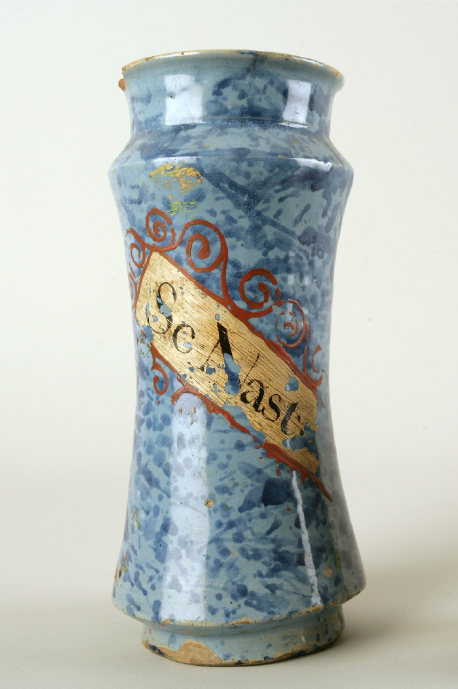Albarelo conservado en Valladolid. Presenta una decoración jaspeada en azul y una cartela escrita con el nombre del medicamento contenido en el mismo