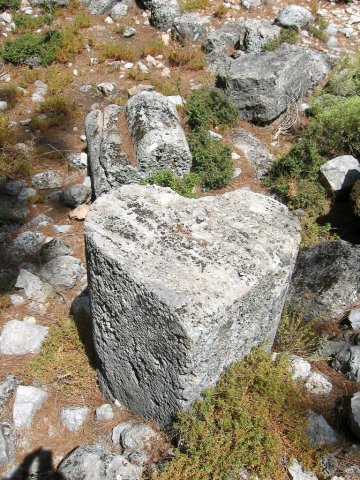 Vista de Pinara en la cual aparecen dos piedras en forma de corazón. En primer plano, una que se apoya sobre una de sus caras planas, con el vértice apuntando al espectador. Tras ella, otra tumbada, mostrando la parte correspondiente a las aurículas del corazón