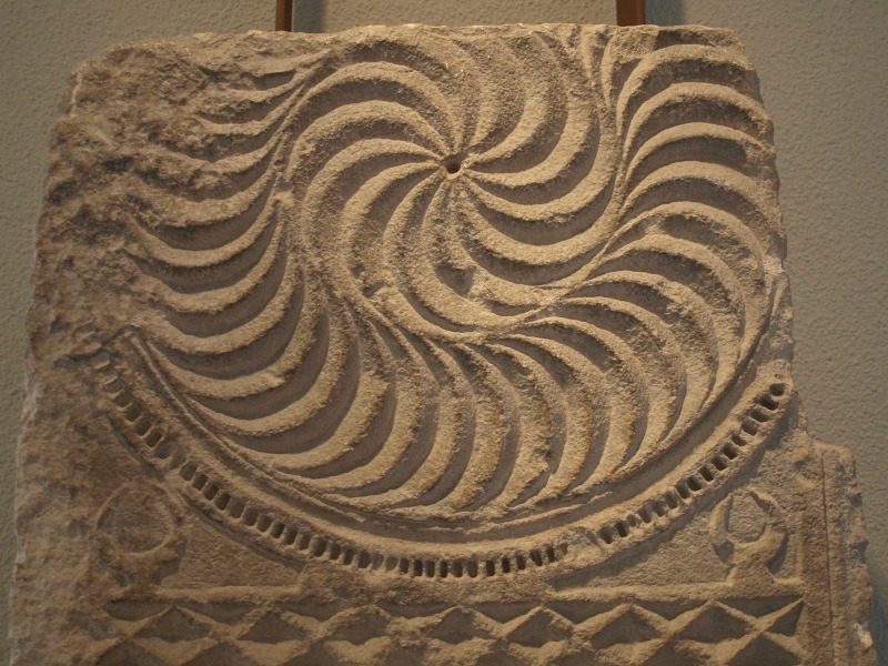 Estela romana con un motivo de dos espirales concéntricas, aunque con distinto sentido de giro