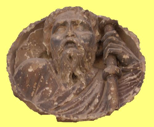 En este medallón aparece el apóstol Santiago de medio torso, apoyado en un báculo, vestido con una túnica y con el ala de un sombrero de peregrino colgándole por la espalda, sujetado sobre el pecho mediante un cordón