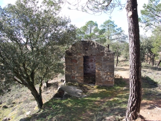 Caseta situada tras el cementerio, al borde mismo del barranco del Vado, antiguo polvorín. Muros de mampostería. Carece de puerta y techo