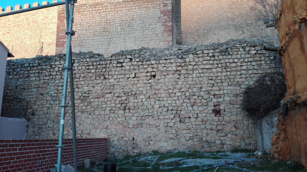 Detalle del mayor lienzo de muralla perimetral del castillo que permiten ver los edificios que lo tapan