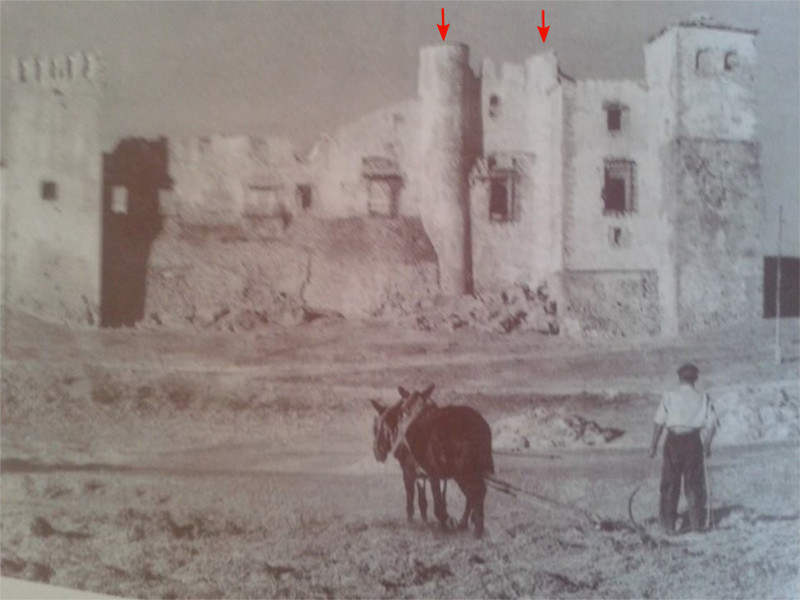 Fotografía antigua con una escena de trilla en las eras, con el castillo en ruinas al fondo