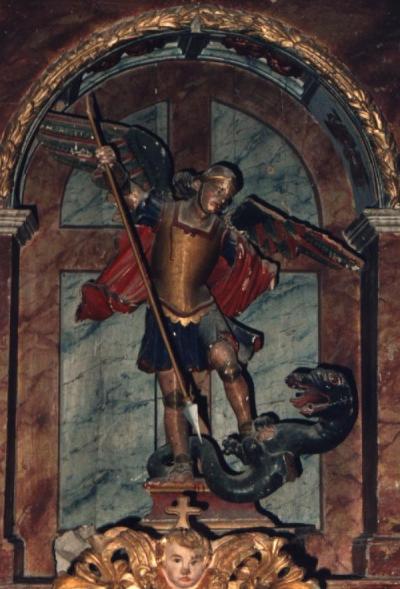 Escultura de San Miguel Arcángel, representando alanceando al diablo representado como dragón, al que retiene con el pie izquierdo
