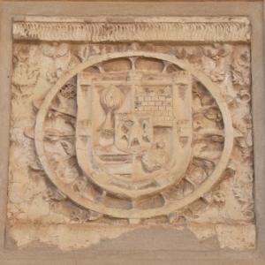 Escudo en piedra de los Villanuño, gotizante, rodeando de una rueda de Santa Catalina. Situado en la fachada del actual convento en La Alameda