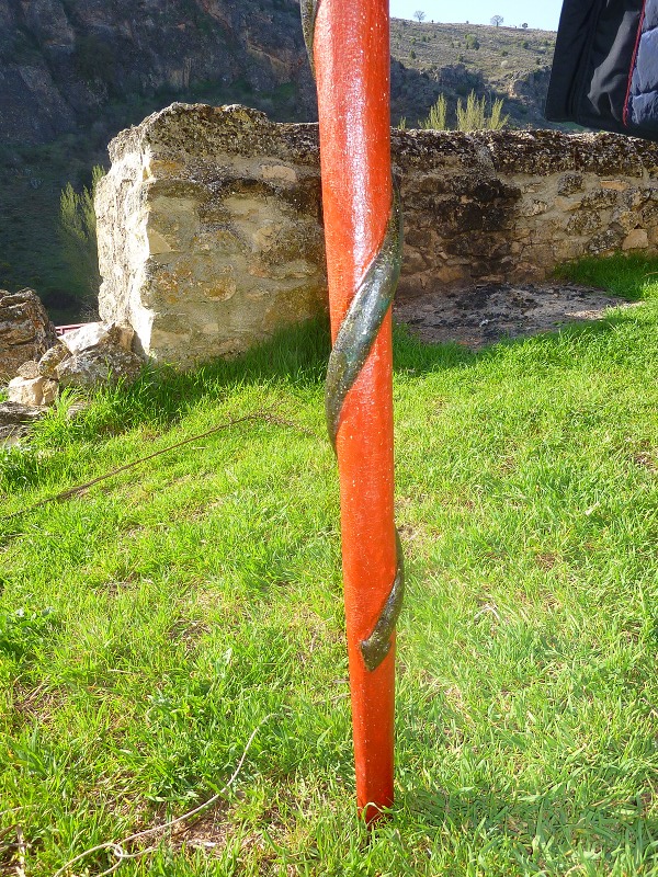 El extremo inferior del báculo tras ser restaurado, mostrando una cola de serpiente de color verde que se enrosca en torno a una vara de color rojo