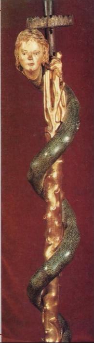 Báculo existente en el Museo de la Catedral de Segovia que representa a una serpiente con cabeza de mujer rubia enroscada en torno al vástago del cirio