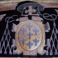 Escudo de armas de Fernando Niño, consistente en siete flores de lis, bajo capelo cardenalicio. Se halla en la reja de la Capilla de las Reliquias de la catedral de Sigüenza