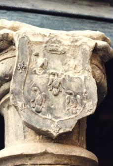 Uno de los escudos idénticos de piedra caliza finamente tallada que se encuentran en el patio de la casa