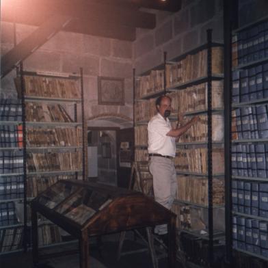 Fotografía del autor subido a una escalera en la sección de Libros de Dinero en el Archivo de la Catedral. Año 2003